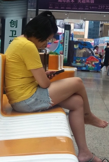 商场里玩手机的美腿少妇